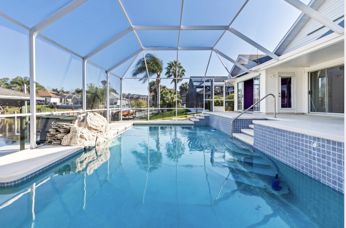 Screened lanai and pool enclosure over a canal at a Flagler Beach home
